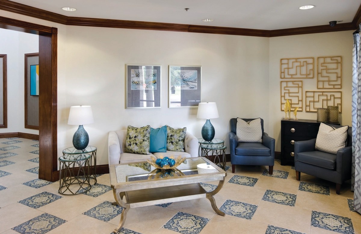A cozy living room with stylish furniture and decor, featuring a sofa, armchair, and coffee table.