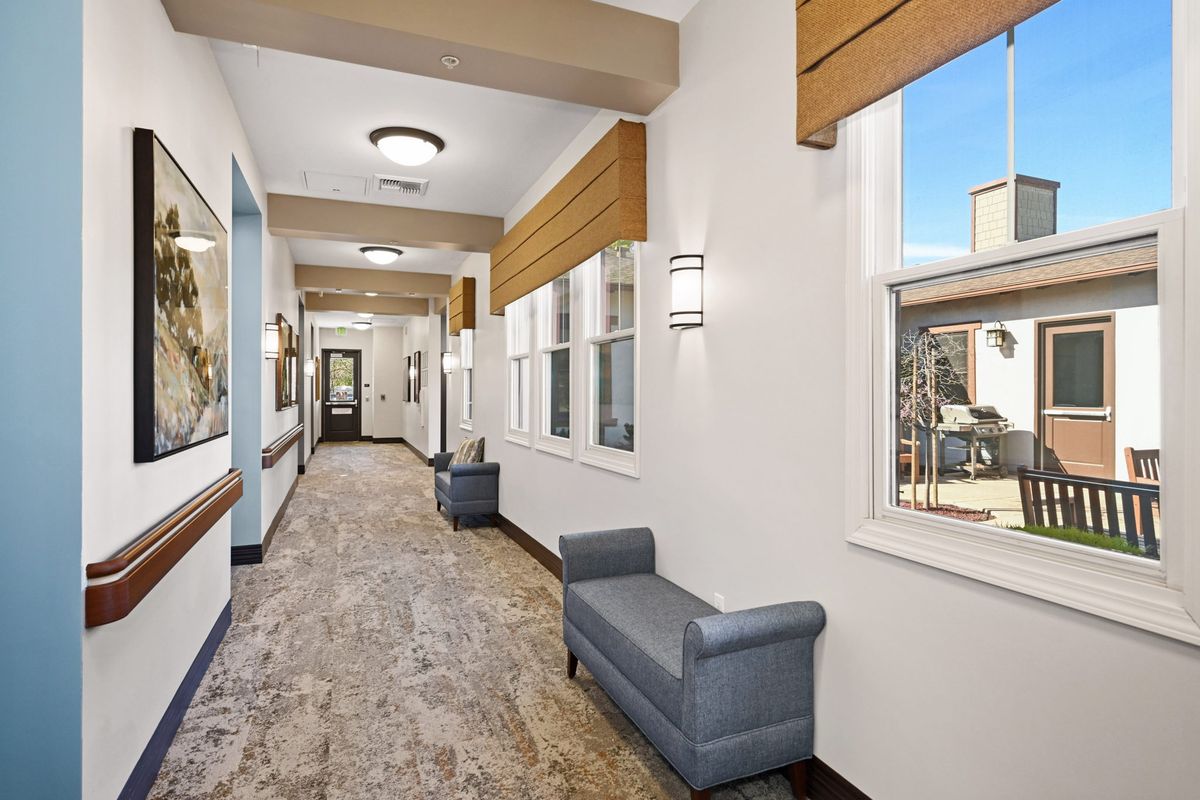 A modern hallway with comfortable seating and large windows.