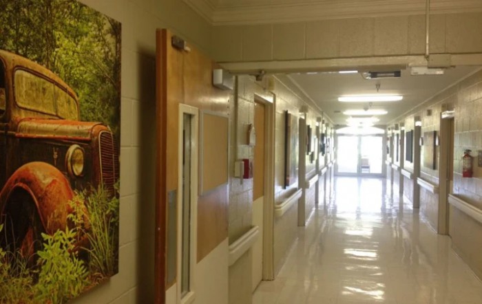 A brightly lit hospital corridor with doors on both sides.