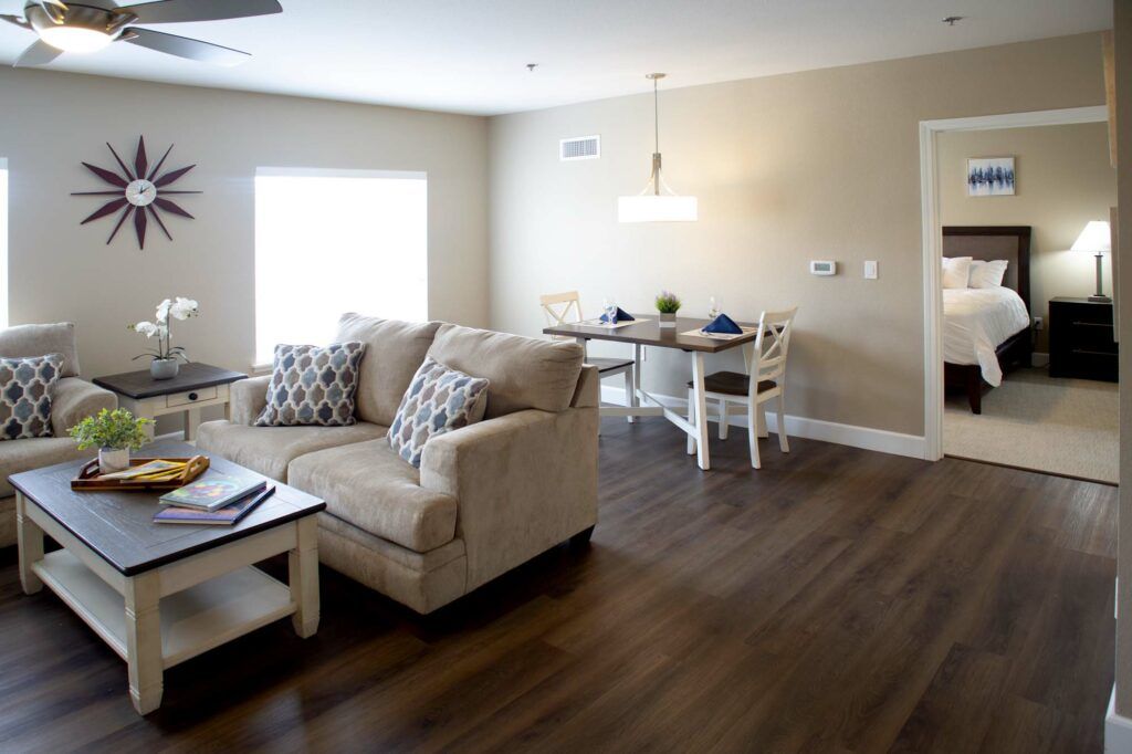 A cozy living and dining area with a modern design, featuring a comfortable sofa and hardwood floors.