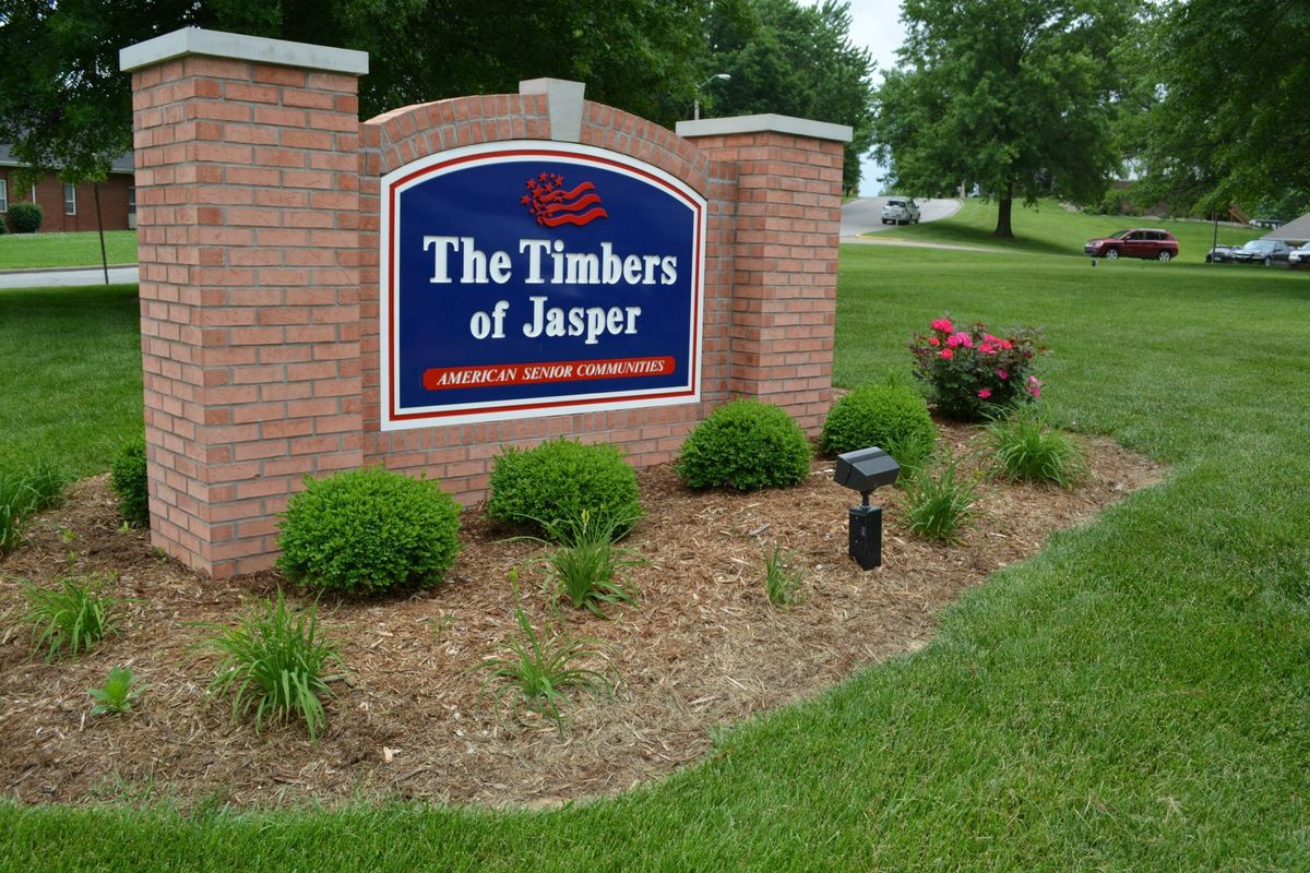 Entrance sign for 'The Timbers of Jasper' surrounded by well-maintained landscaping.