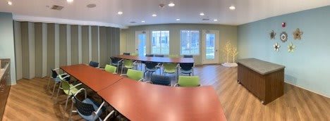 A well-lit conference room with tables and chairs arranged for a meeting.