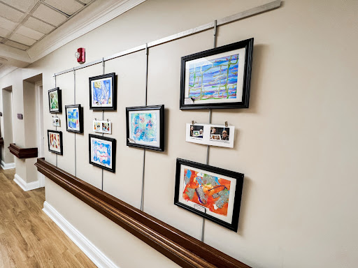 A corridor displaying a collection of framed artworks, adding color and creativity to the space.