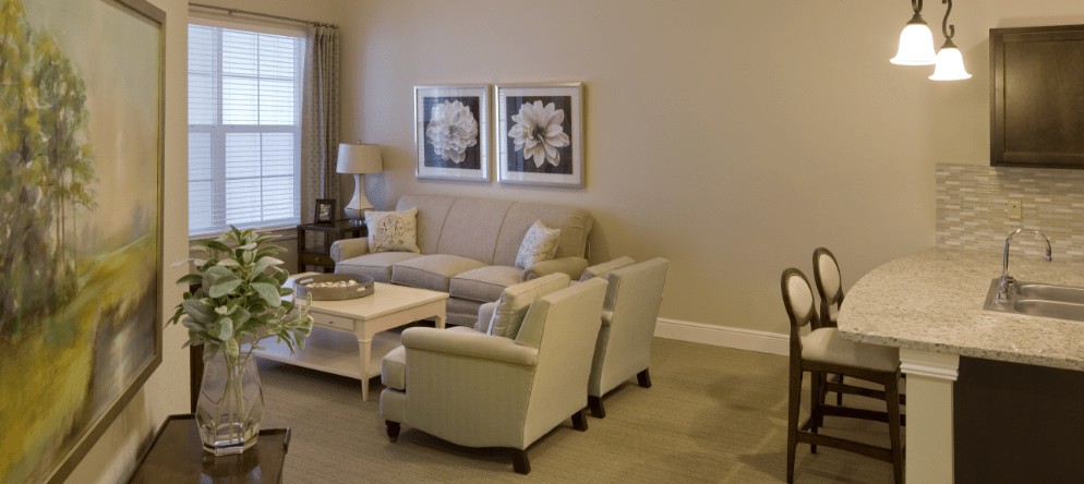 A cozy living room with a neutral color palette, featuring a sofa, armchairs, and a coffee table.
