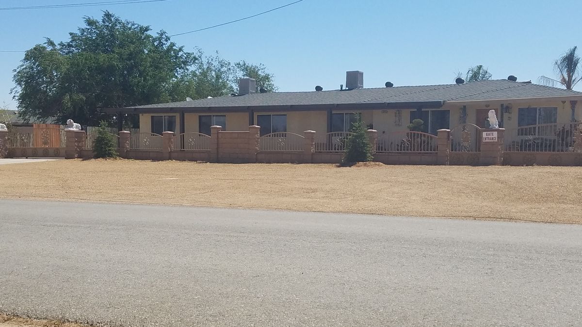 A single-story brick house with a dry yard in a suburban area.