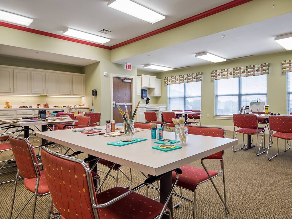 An art room equipped with tables, chairs, and painting supplies.