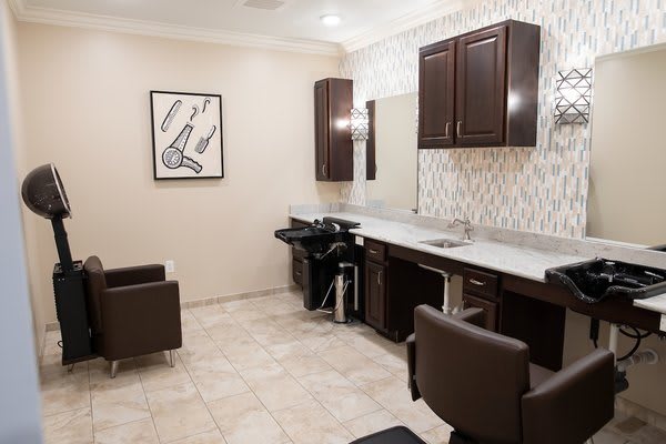 Modern hair salon interior with styling stations and washing area.