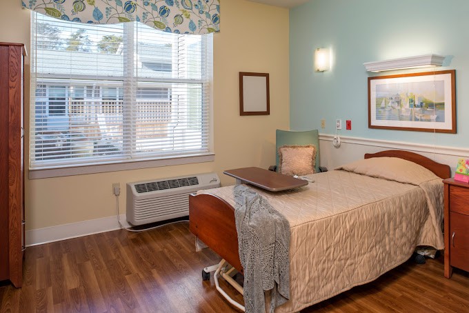 A hospital room with a bed, window, and chair, featuring a comforting ambiance.
