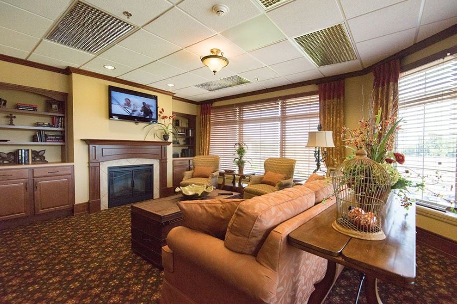 A cozy living room featuring comfortable seating, a fireplace, and a television.