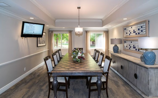 A beautifully designed dining room featuring a long wooden table, elegant chairs, and ample natural light.