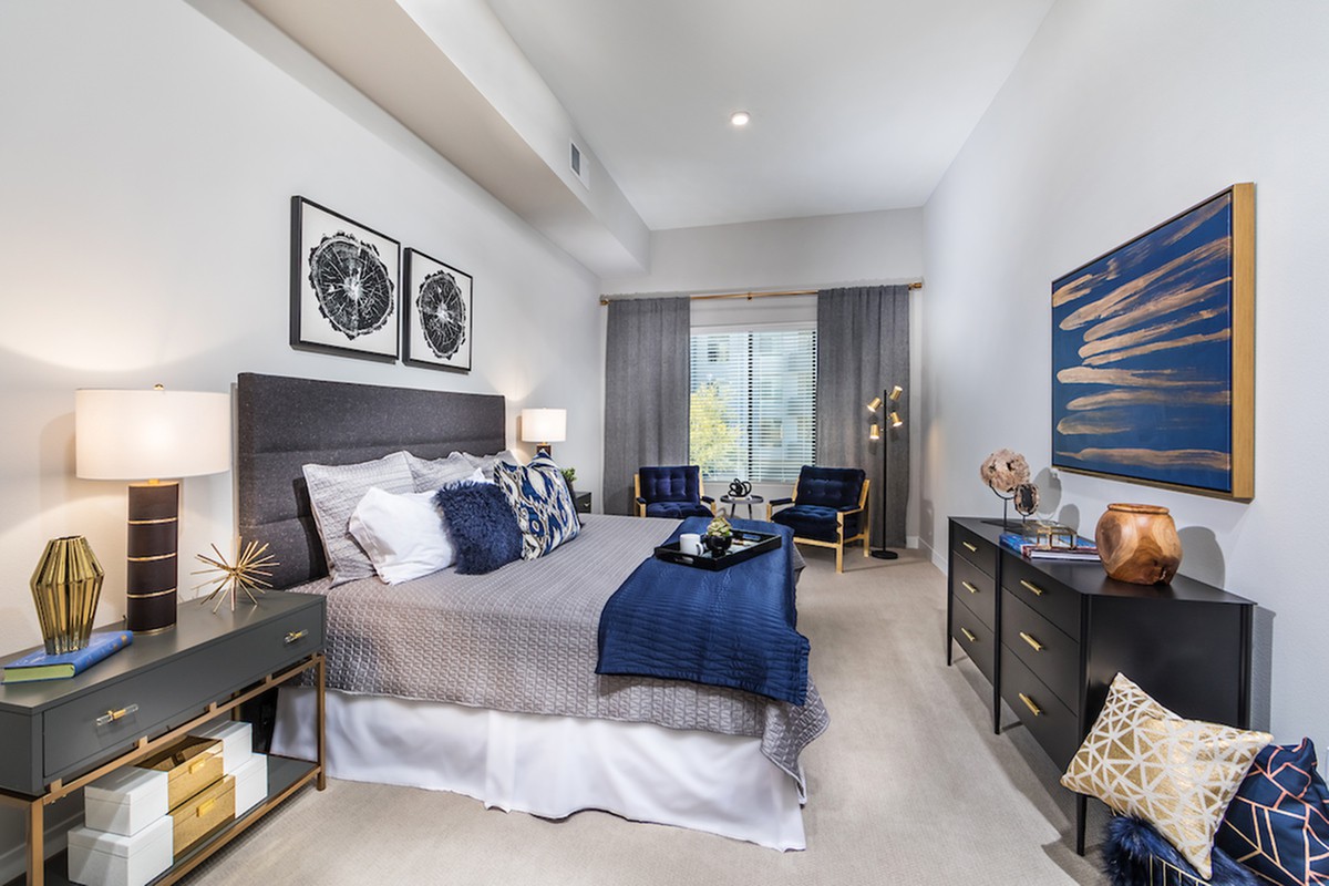 A modern and stylishly decorated bedroom with a focus on blue and gray tones.