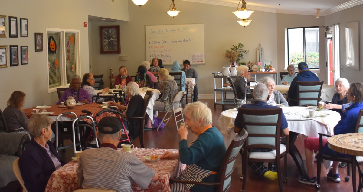 A group of elderly people socializing in a nursing home environment.