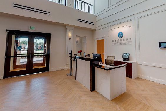 A modern reception area with a central desk and office entrance.