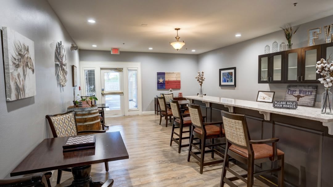 A modern lounge area with chairs, tables, and artwork on the walls.