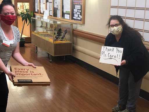 Healthcare workers expressing gratitude with a thank you sign, showcasing community support.