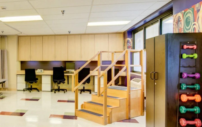 A rehabilitation room equipped with therapy stairs and exercise areas.