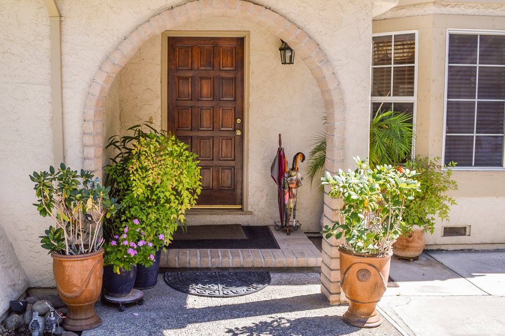 A welcoming entrance with potted plants and an arched doorway.