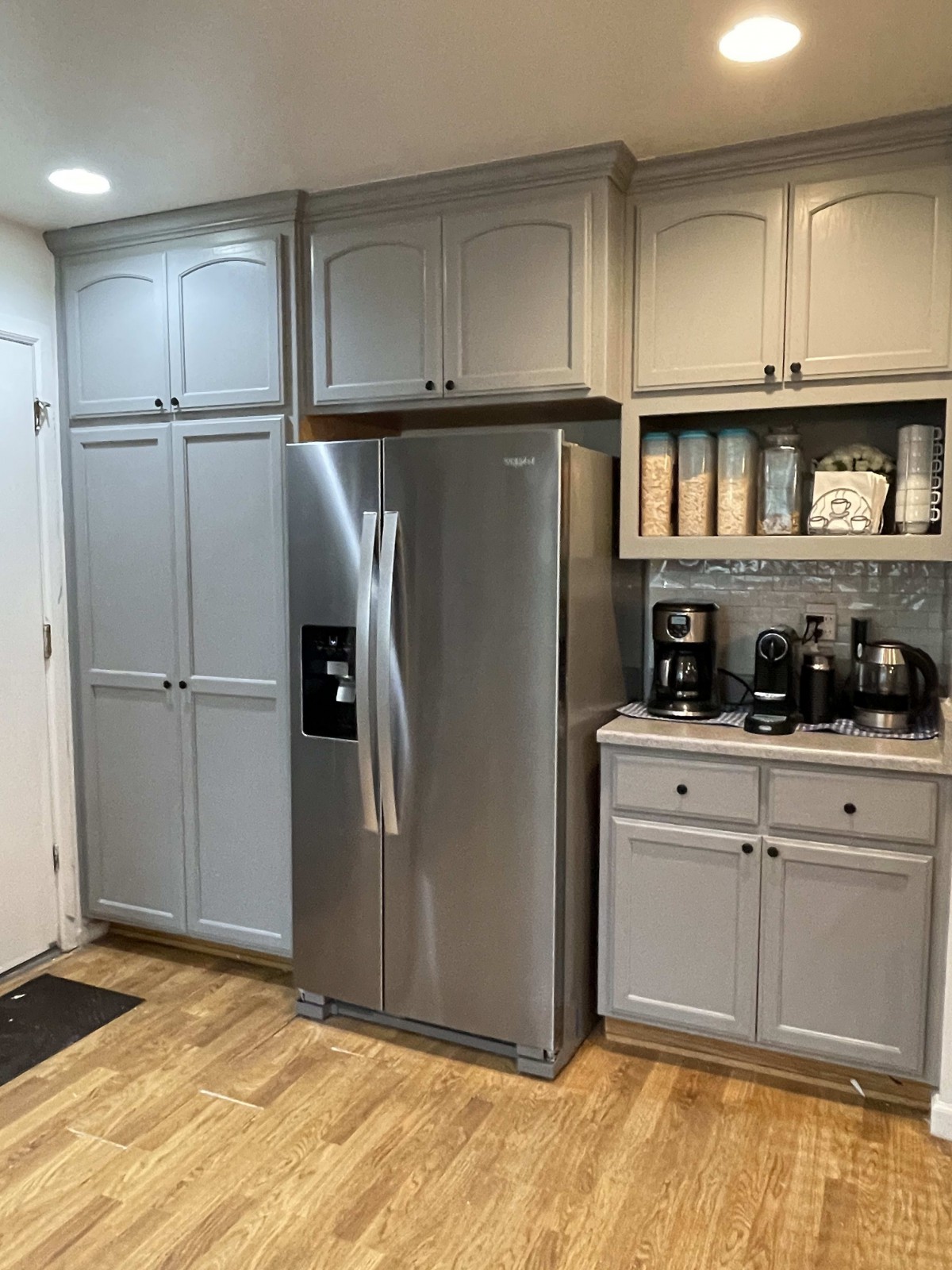 A well-organized kitchen with gray cabinets and stainless steel appliances.