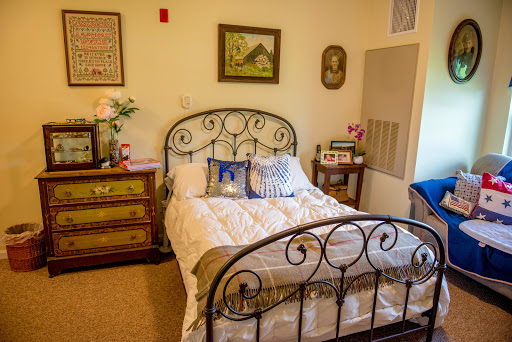 A cozy bedroom featuring a wrought iron bed frame, decorative pillows, and charming wall art.