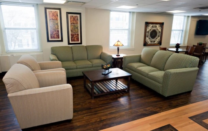 A cozy living room with sofas and armchairs arranged around a wooden coffee table.