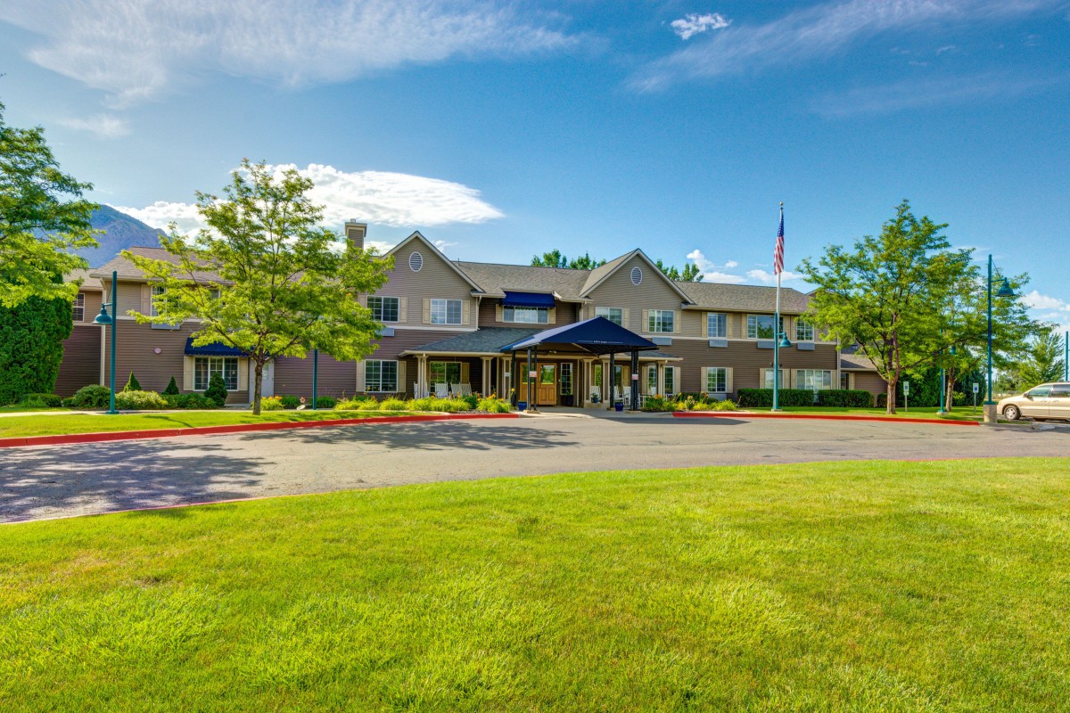 A well-maintained building with a landscaped lawn and clear blue sky.
