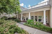 A scenic view of a building with a garden and pathway surrounded by lush greenery.