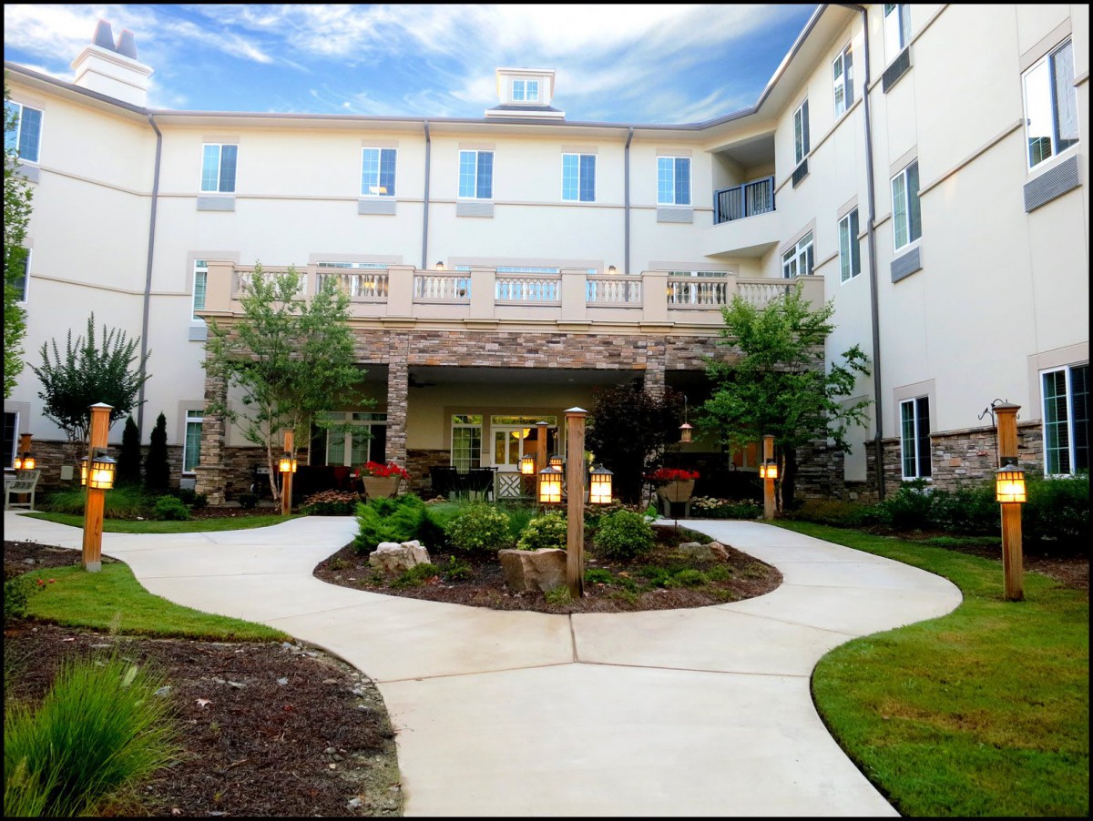 A well-maintained building entrance with landscaped greenery and a clear pathway.
