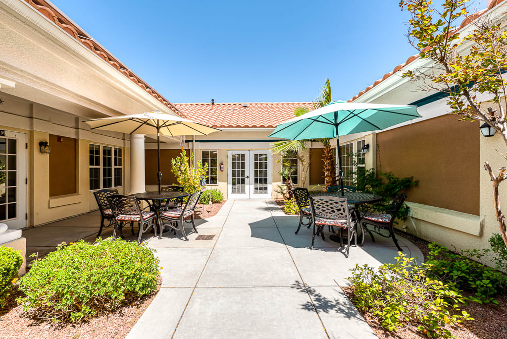 A sunny courtyard with patio furniture and umbrellas.