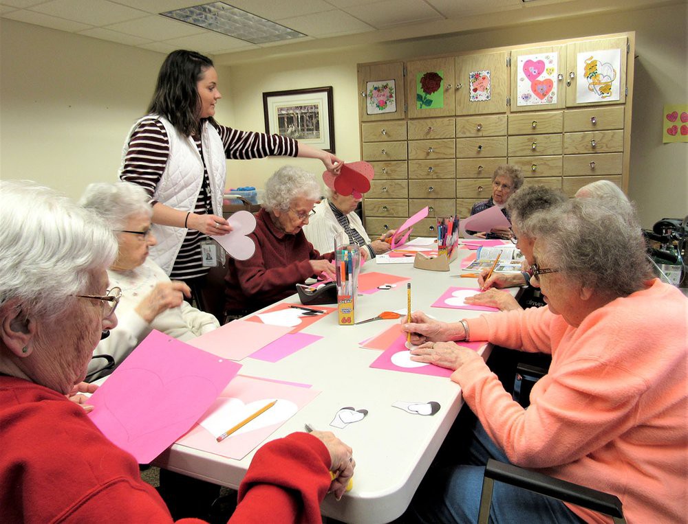 A group of older adults participating in an arts and crafts session, creating decorations with paper.