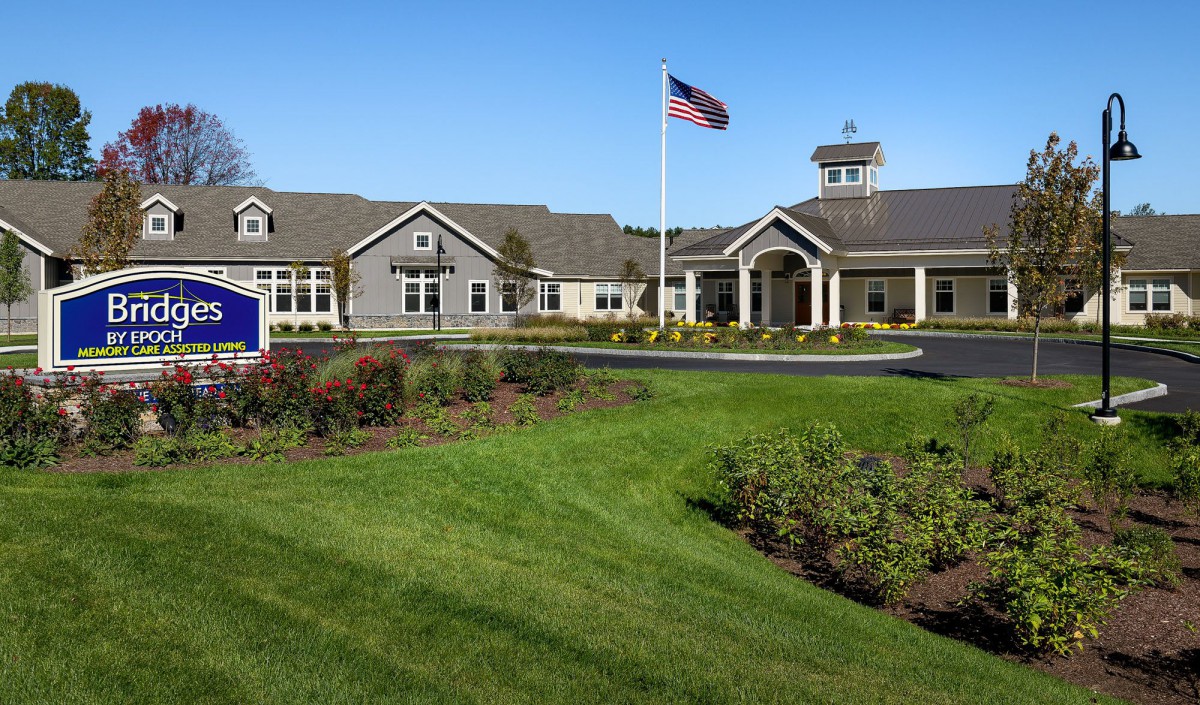 A neatly maintained building with an American flag and landscaped grounds.