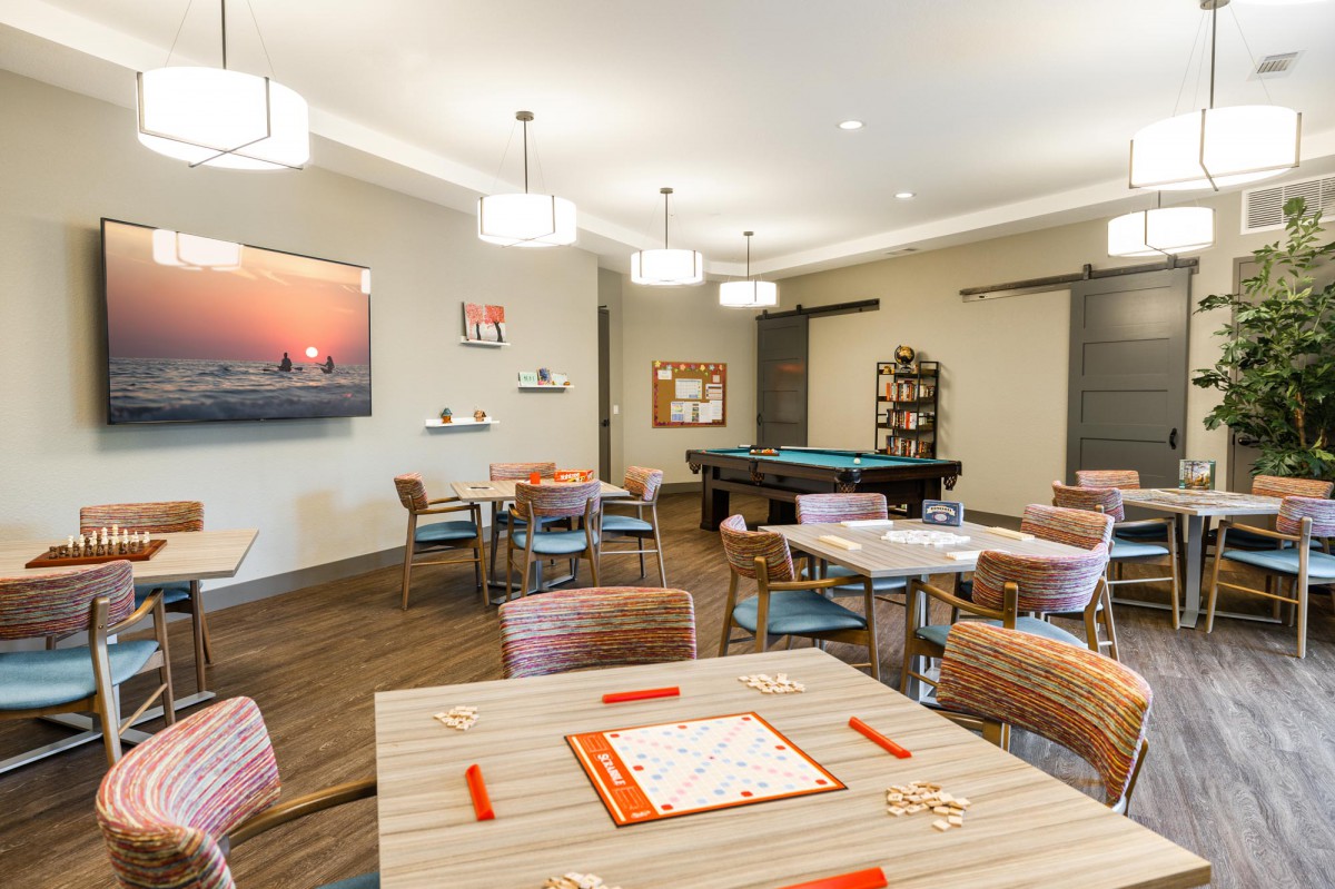 A modern game room featuring a pool table and seating area with contemporary decor.