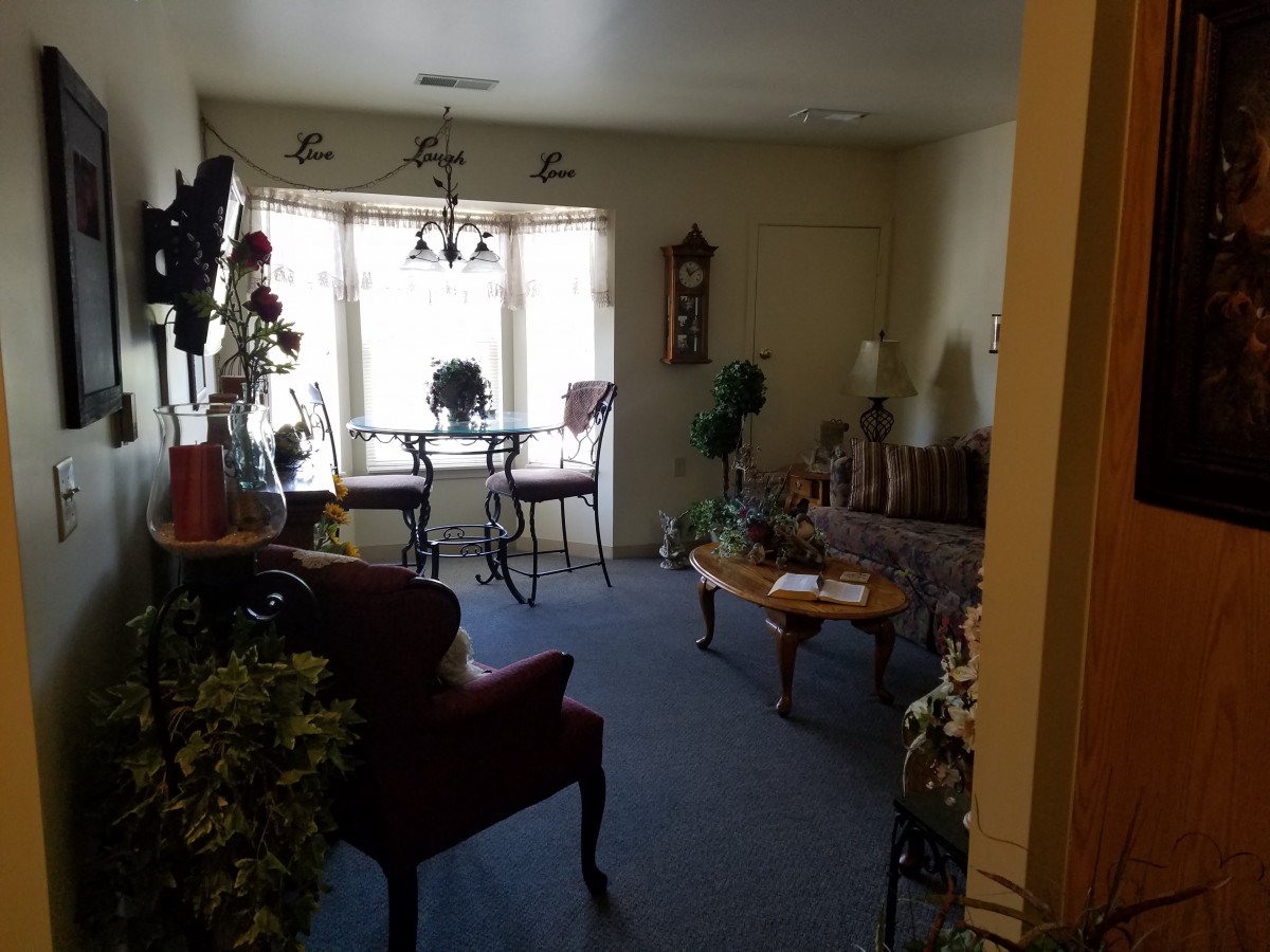 A cozy living room with dining area, featuring various furnishings and decor.