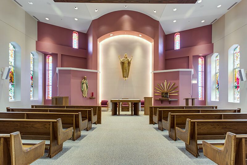 Interior view of a church sanctuary with pews and an altar.
