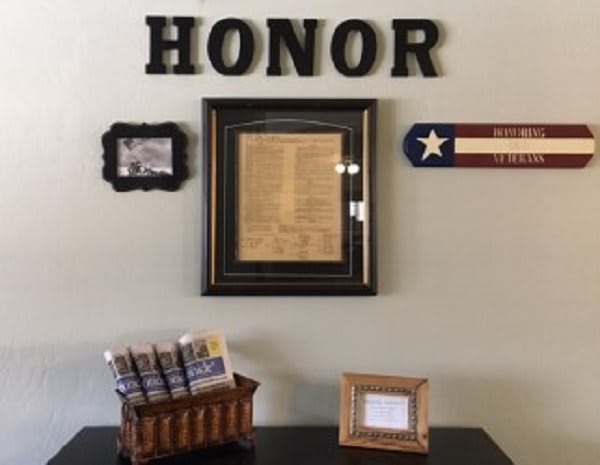 A wall display featuring the word 'HONOR', a framed document, and a Texas-themed decoration.