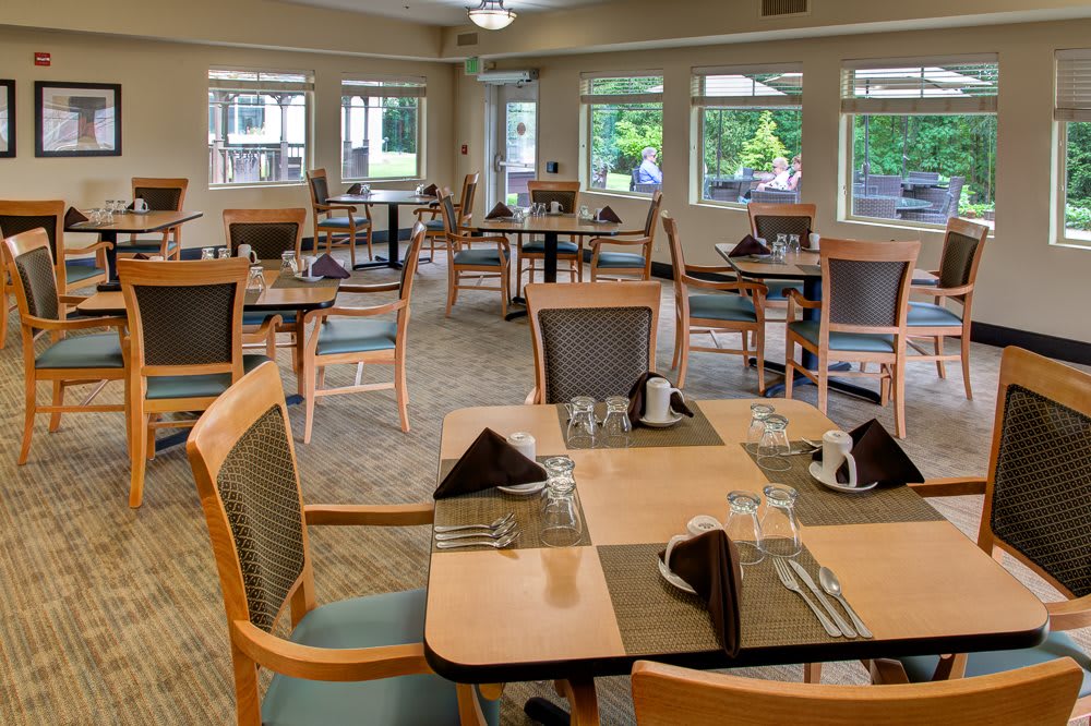 A neatly arranged dining room with tables set for a meal.