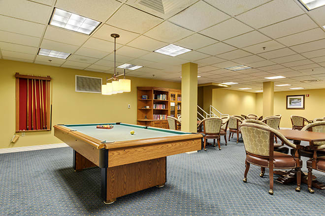 A spacious game room featuring a pool table and comfortable seating.