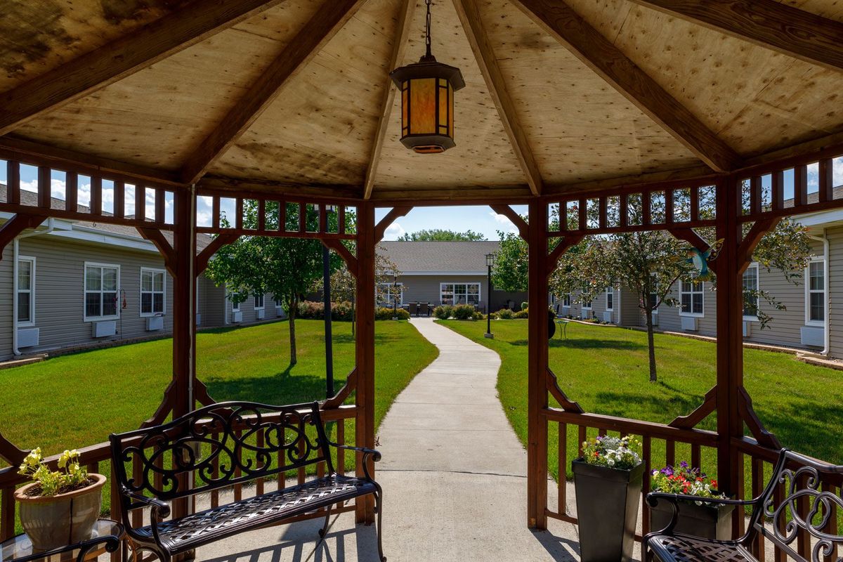 A view from inside a gazebo looking out onto a landscaped garden with a winding pathway.