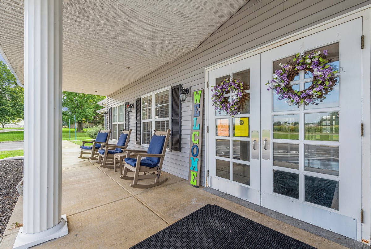 An inviting porch with comfortable chairs and decorated double doors.