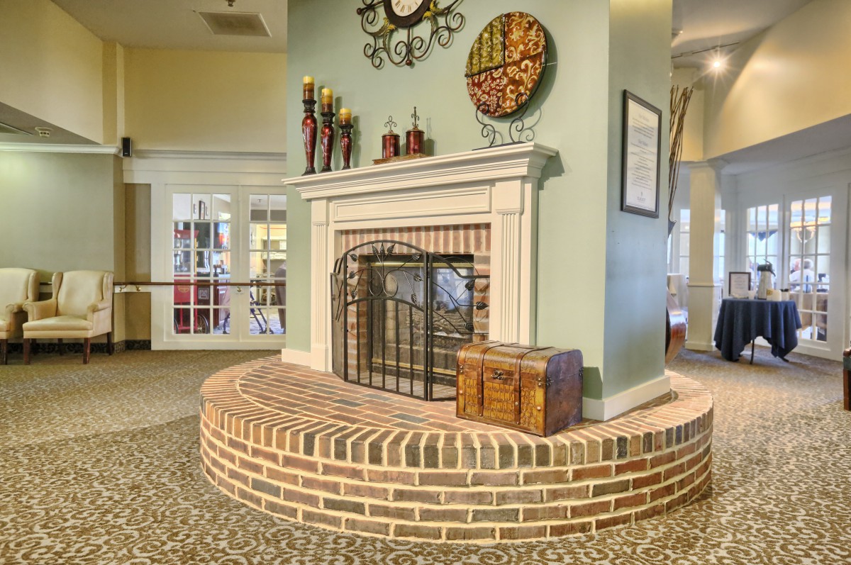 A cozy interior featuring a brick fireplace with decorative items on the mantel.