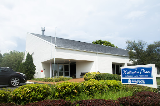 A modern commercial building with landscaped greenery in front.