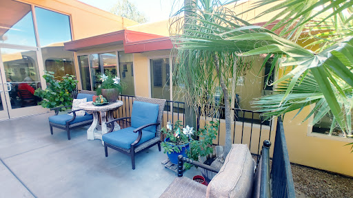 A serene outdoor patio area with comfortable furniture and vibrant plants, perfect for relaxation.