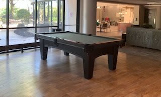 A pool table set up in a well-lit recreational area.