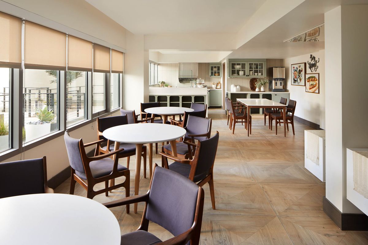 A modern kitchen and dining area with wooden floors and contemporary furnishings.