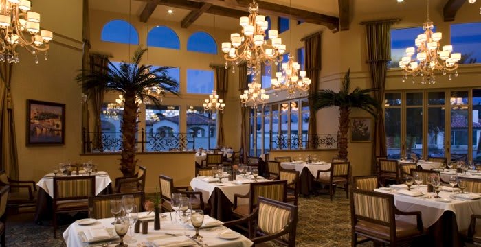 A beautifully decorated restaurant with elegant chandeliers and well-arranged dining tables.
