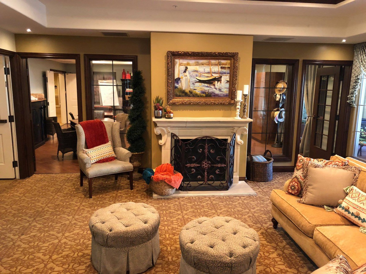 A cozy living room with elegant furniture, a fireplace, and warm decor.