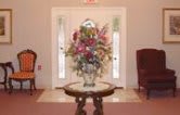 A beautifully arranged vase of flowers on a small table in an entryway.