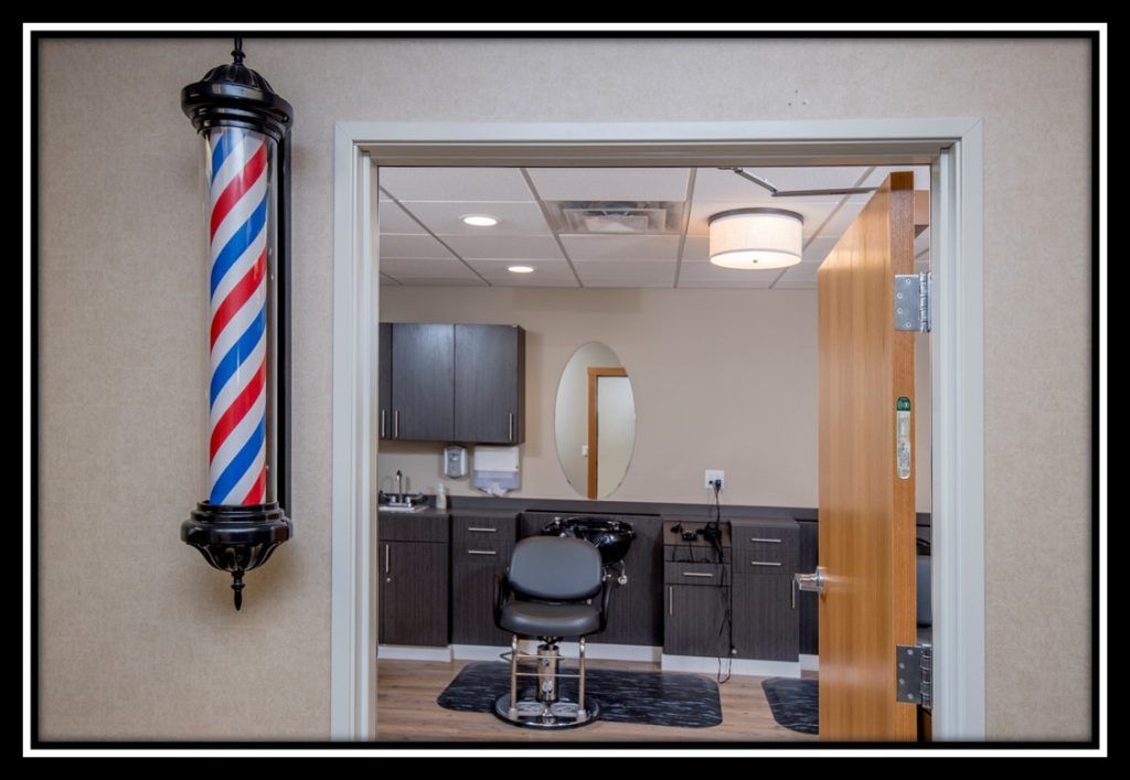 A modern barber shop interior with a classic barber pole outside.