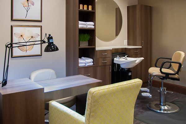A modern salon interior featuring a stylish chair, sink, and decorative elements.