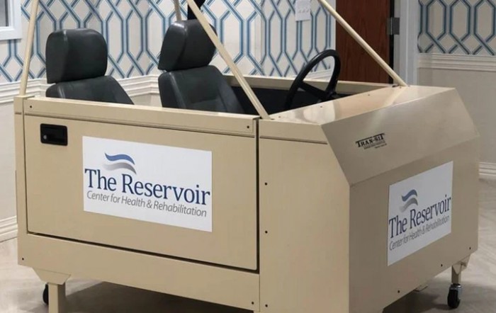 A beige cart with two seats and steering wheel, labeled 'The Reservoir', located indoors.