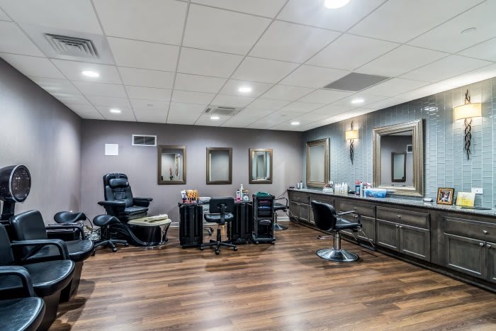 A modern hair salon interior with styling stations and chairs.